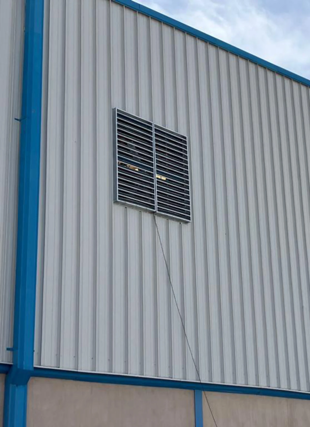 Louver instalado sobre fachada metálica de nave industrial
